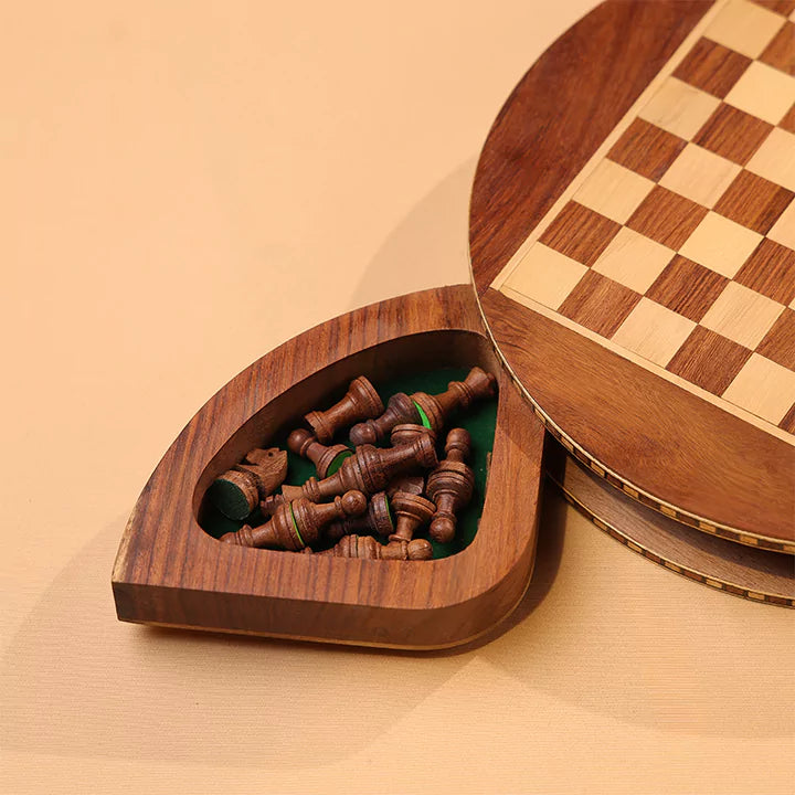Wooden chess set with pieces inside a heart-shaped box on a beige background