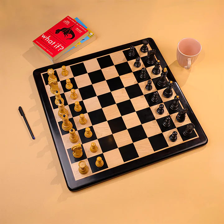 Chessboard with pieces, a book titled 'what if?' and a cup on a beige surface