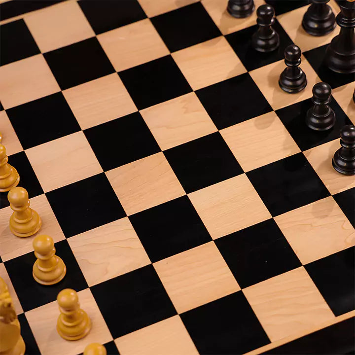 Wooden chessboard with black and white pieces.