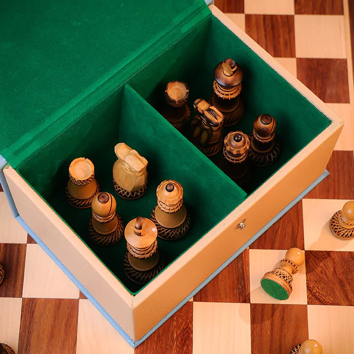 Wooden chess pieces in a green-lined box on a checkered wooden floor