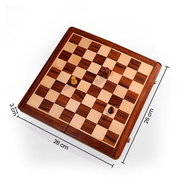Wooden chessboard with pieces on a beige surface, next to a book and a mug.