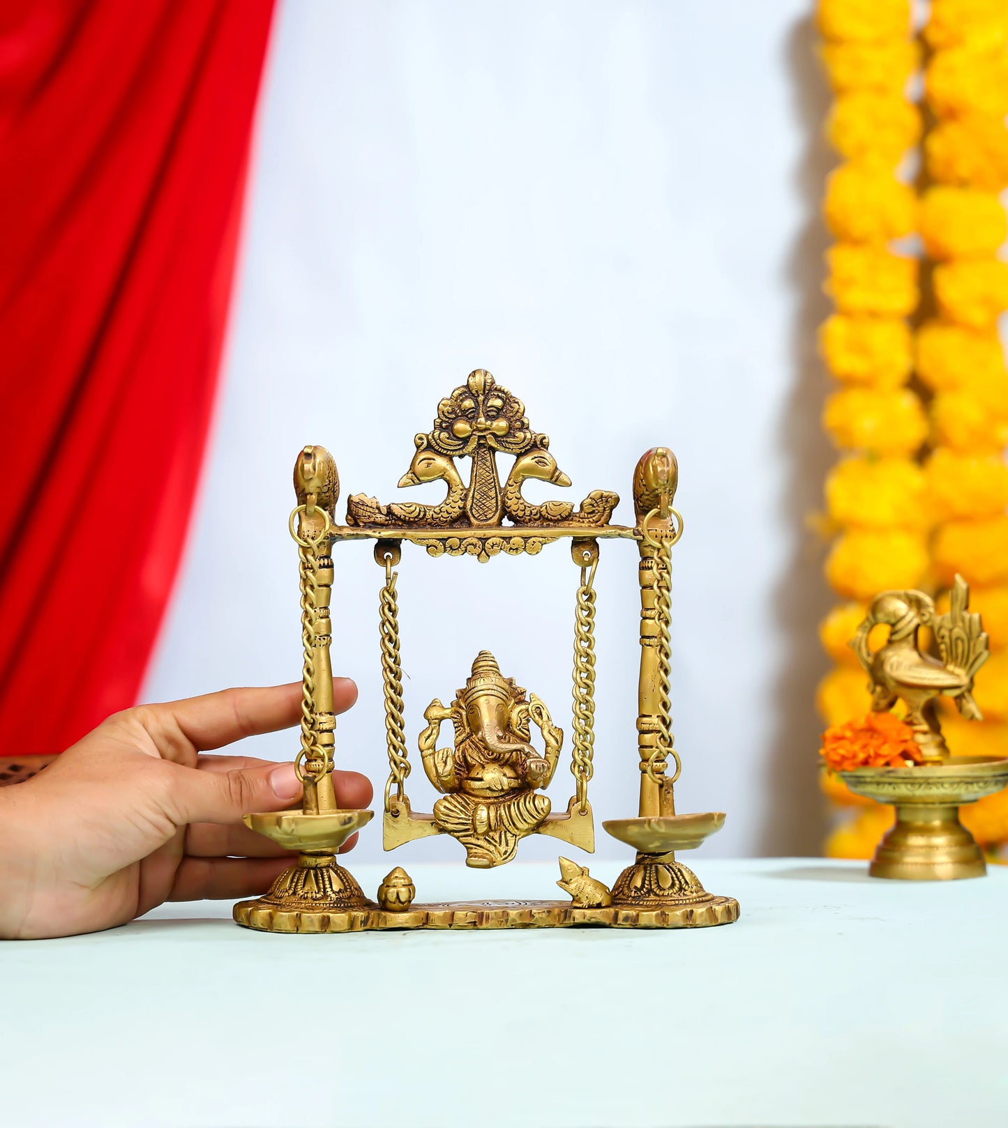 Brass Ganesha Idol On Ornate Jhula With Intricate Detailing